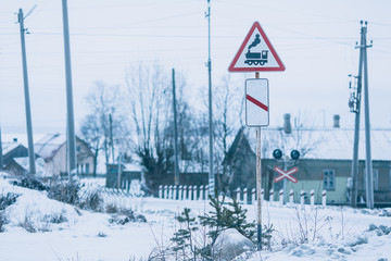 Railroad crossing sign in a village in winter