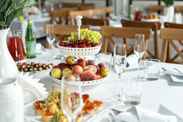 Multilevel bowl with fruits on the festive table.