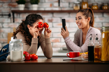 Sisters cooking together. Two friends having fun in kitchen. 