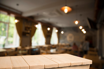 Empty brown wooden table and blur background of abstract of resturant lights people enjoy eating ,can be used for montage or display your products