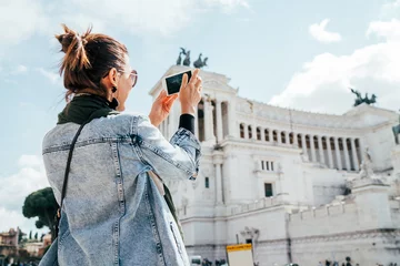 Foto op Canvas Young alone caucasian female tourist taking a photo of Victor Emmanuel II Monument using a modern smartphone on Piazza Venezia in Rome, Italy. © Soloviova Liudmyla