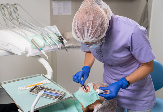 The dentist uses a cotton swab to apply the medicine to the patient’s gums, in order to heal the gums as soon as possible after brushing the teeth with tartar.
