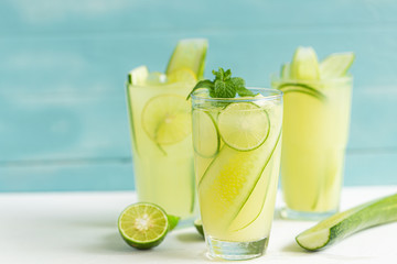 Cucumber juice mix lime in a glass on a white wooden floor in a light blue background, summer drinks nonalcoholic