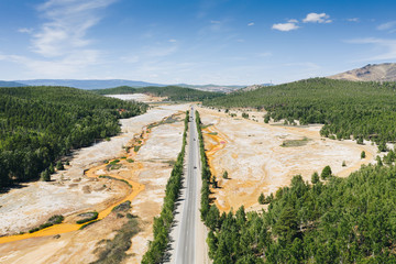 Aerial view of highway in wasteland area among Ural forest. Chemical contamination of natural...