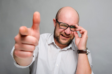 aiming from a finger.  A man depicts a shot from a pistol.  Winks through the glasses