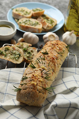 Tasty garlic bread and towel on grey background, close up