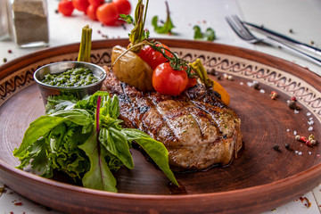 Pork entrecote served with grilled vegetables, mushrooms and pesto sauce, restaurant dish, Horizontal orientation