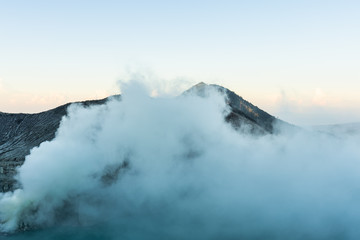 Beautiful Landscape mountain and blue lake with smoke sulfur in the morning in a Kawah Ijen volcano.