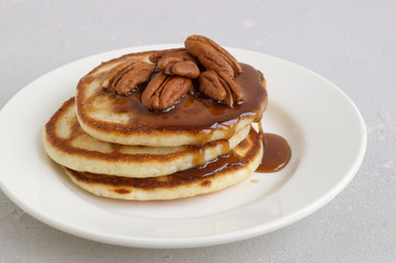 pancakes with caramel syrup and pecans.