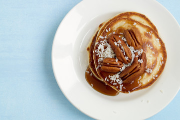 pancakes with caramel syrup and pecans.