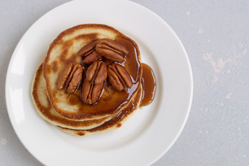 pancakes with caramel syrup and pecans.