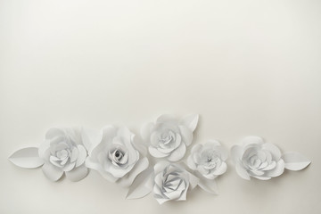 Obraz na płótnie Canvas White paper flowers closeup with copy space on upper part. 