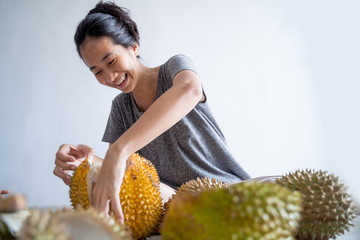 beautiful asian woman eating durian fruit at home - obrazy, fototapety, plakaty