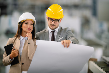 Architects working on construction project. Man and woman discussing work. 