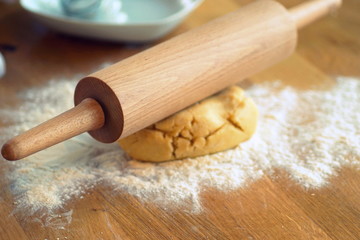 close up of a rolling pin on a piece of dough in the kitchen
