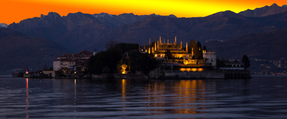 Fototapeta premium Beautiful sunset over a lake in northern Italy, with an island in the center and mountains in the background