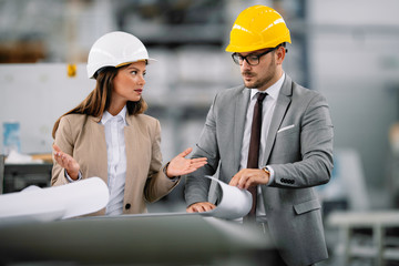Two colleagues architects arguing about project. Man and woman discussing work