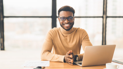 Smiling black manager working at modern office