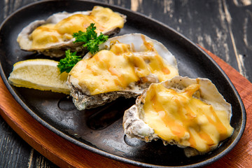 Oysters in a pan in a creamy sauce and cheese