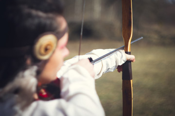 Girls dressed as medieval teaching archery at the field