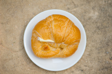 Closed up Croissant with cheese on white dish