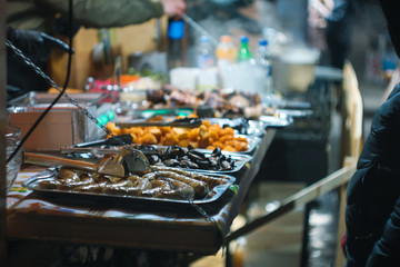 Fried meat sausages on a black background of charcoal.