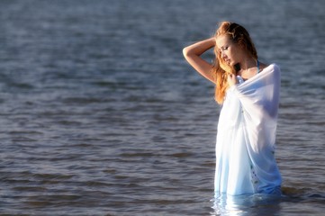 Fototapeta na wymiar Young woman in bikini standing in water in sunshine