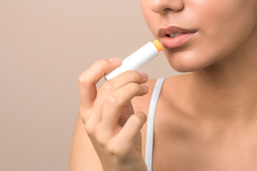 lips care and protection. woman applying balm on lips - obrazy, fototapety, plakaty