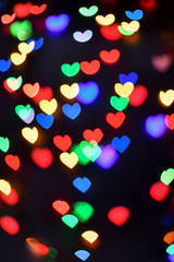 Heart. Abstract bokeh lights in colorful little heart shape on black background. Christmas  and valentines day. Blurred  vertical background.