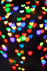 Heart. Abstract bokeh lights in colorful little heart shape on black background. Christmas  and valentines day. Blurred  vertical background.