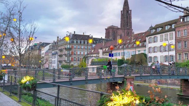 Bicicletas atravesando puente de canal de Estrasburgo al atardecer y decoraci&oacute;n navide&ntilde;a