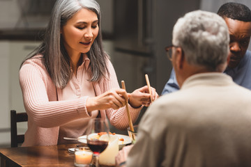 selective focus of multicultural friends talking during dinner