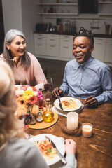 selective focus of multicultural man and woman talking with friend during dinner