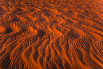 Amazing view of rippled sand dunes texture lit by sunset sun light. Global warming concept