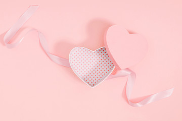 Composition for Valentine's day. Holiday  pink background with gift, white satin bow, ribbon. Valentines Day, Easter, Happy Women's Day, Mother's day. Flat lay, top view, copy space