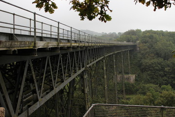 old railway bridge over a deep green gorge on a cloudy day, West England, Dartmoor National Park