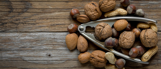 top view of various  dried fruit and nutcracker on old wood