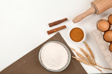 Flat lay composition with raw eggs and other ingredients on white table. Baking pie