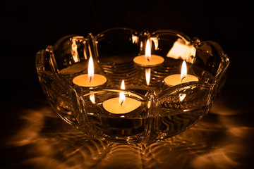 Obraz na płótnie Canvas Fortune telling with floating candles. 4 burning candles float in a crystal bowl with water.