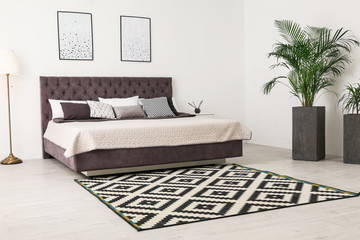 Elegant interior of modern comfortable bedroom with green plants