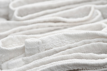 Fototapeta na wymiar Close up of sloppily folded white bathroom towels