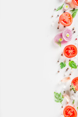 Fresh cherry tomatoes with basil, herbs and spices on white background, copy space for text top view. Ripe raw vegetables flatlay. Cooking food background, simple pattern