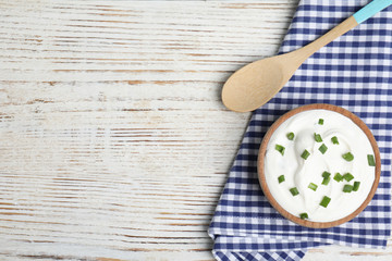 Fresh sour cream with onion on white wooden table, flat lay. Space for text