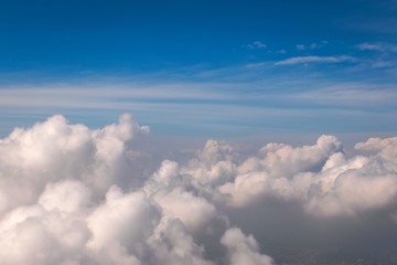 Fototapeta na wymiar Dreamy, fluffy clouds (cumulus) on blue sky seen from above. Cloudscape at high altitude. Heaven, flying, freedom concept.