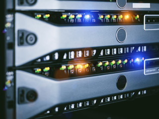 Server units in cloud service data center showing flickering light indicators for massive data connection bandwidth, close up shot.