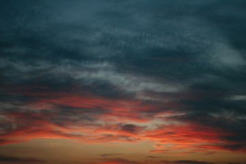 Sky at sunset, gray red clouds closeup background texture