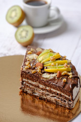 Tasty piece of chocolate cake with fruits, chocolate, apple, kiwi on cup of coffee americano, white background. Organic dessert sugarless. Healthy eating.