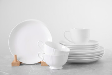 Set of clean tableware on light grey marble table