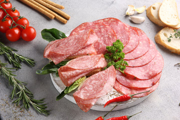 Italian cuisine. Ham and sausage. Sliced meat on a white background. vegetables and bread.Background image. Copy space