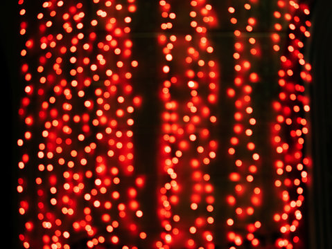 Blurred Abstract Pattern With Defocused Red Light Chains. Round Lamps Dots